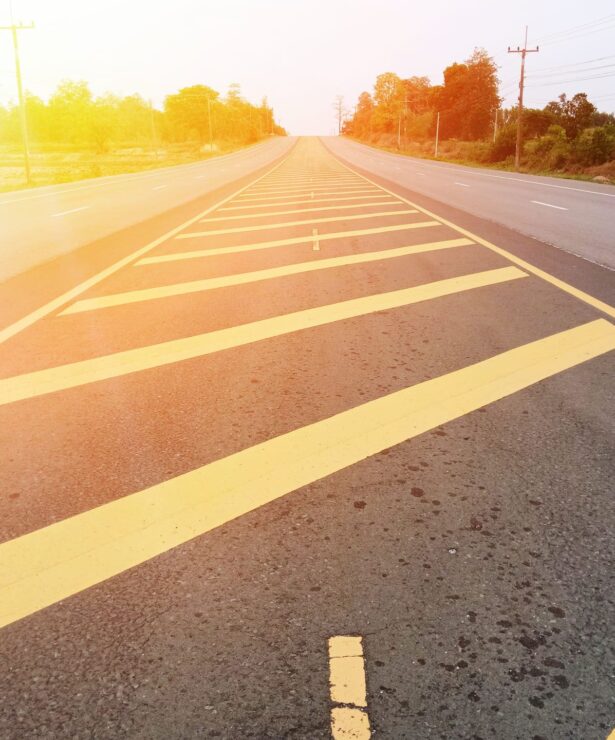 Asphalt roadway with yellow lane markings, illustrating paving quality and maintenance, relevant to Strada Paving's services.